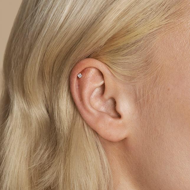 Silver stud in an upper helix ear piercing