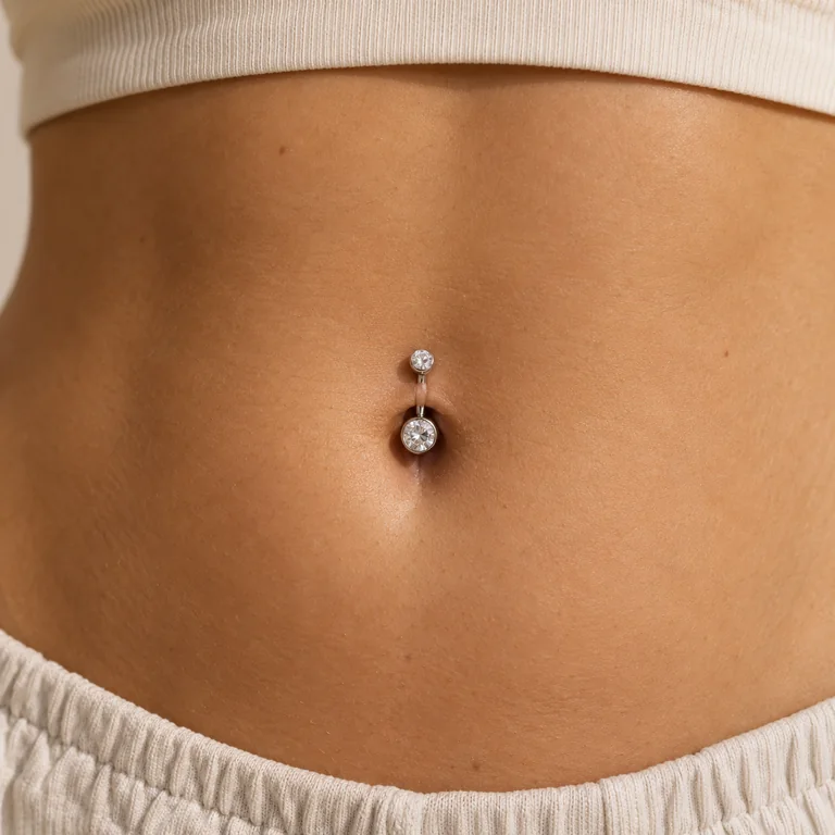 Silver belly bar with clear gems in a navel piercing
